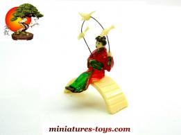 La geisha aux oiseaux assise sur le pont du jardin japonais miniature vintage