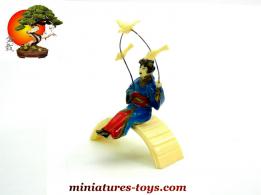 La geisha aux oiseaux assise sur le pont du jardin japonais miniature vintage