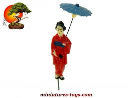 La geisha a l'ombrelle en robe rouge du jardin japonais miniature vintage